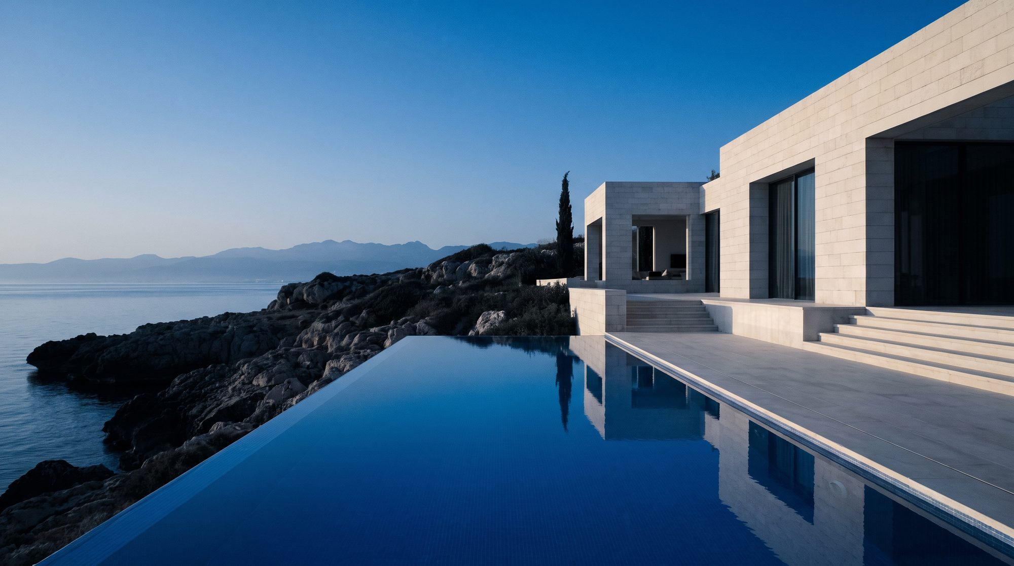 Alacakaranlıkta Kuzey Kıbrıs kıyısında kayalık burun üzerinde modern villa